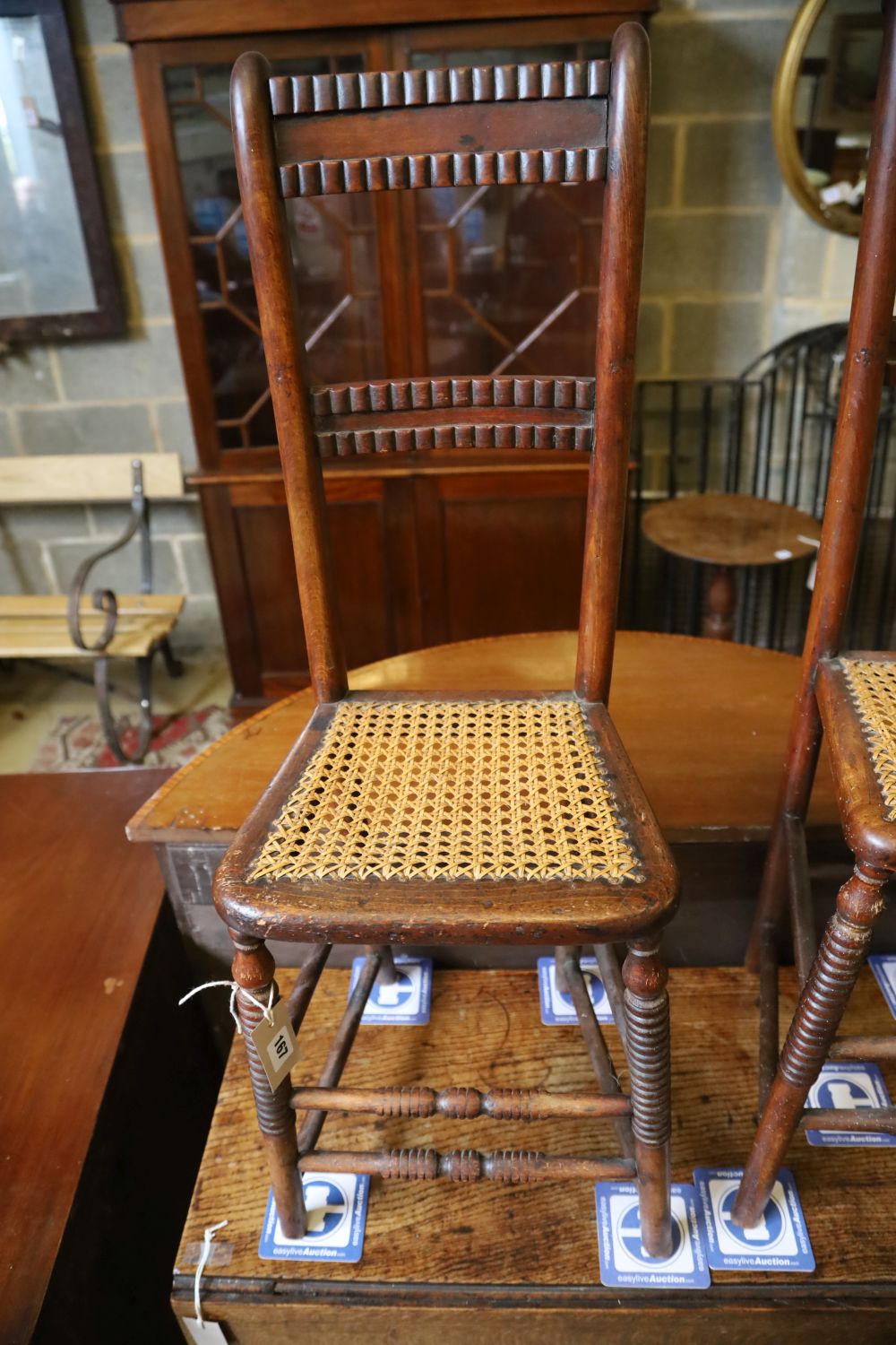 A pair of Regency provincial cane seat correction chairs (one cut down)